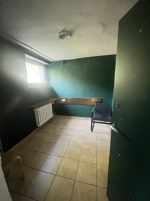 Narożnik pokoju z zielonymi ścianami, oknem i krzesłem