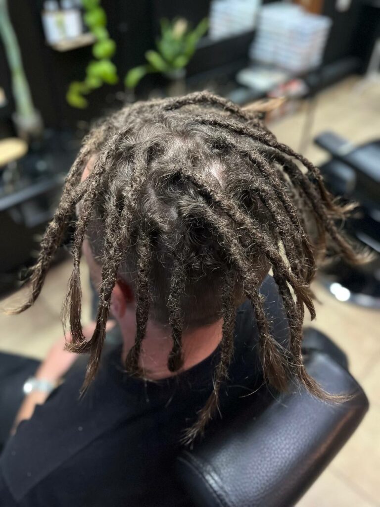 Brązowe dredy po serwisie w FREAK SALON, widok z tyłu na fotelu w salonie